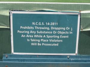 Clumsy wording aside, it is against NC state law to throw, drop, or pour objects onto the field. Courtesy of Greensboro Grasshoppers, NC.